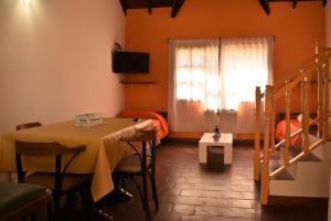 Cette chambre comprend une table, un lit et une fenêtre. dans l'établissement Cabañas El Regreso, à Merlo