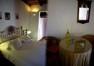 Un dormitorio con una cama y una mesa con una botella de vino en Monte do Vale, en Vila Boim