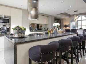 a kitchen with a counter with bar stools at Old Chapel House in Barnoldswick