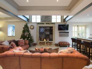 a living room with a large couch and a christmas tree at Old Chapel House in Barnoldswick