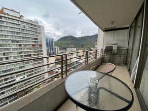 a table on a balcony with a view of a city at Brizen Apartments - Manuel Montt in Santiago