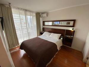 una camera con un grande letto e una finestra di Brizen Apartments - Manuel Montt a Santiago