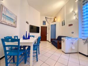 a living room with a table and blue chairs at CasaViva - Cozy Trilo in Camogli with AC in Camogli