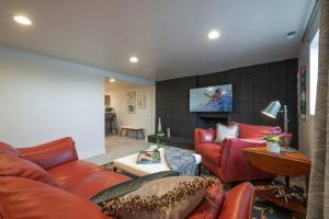 a living room with red furniture and a flat screen tv at Modern Apartment close to freeway! in Salt Lake City