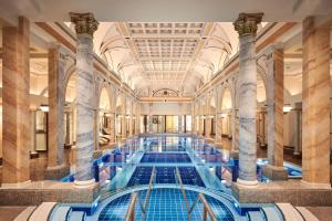 ein großer Pool mit Säulen in einem Gebäude in der Unterkunft Grand Resort Bad Ragaz in Bad Ragaz