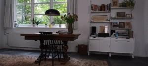 een thuiskantoor met een bureau en een raam bij Villa Conti in Dordrecht