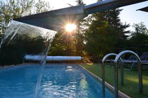 a swimming pool with a water fountain in a yard at Atelier du Philosophe in Saint-Victor