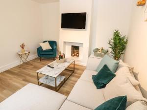 a living room with a couch and a fireplace at Alma Cottage in Buxton