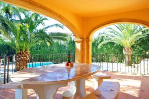 un patio con tavolo e 2 palme di Villa Fustera - PlusHolidays a Benissa