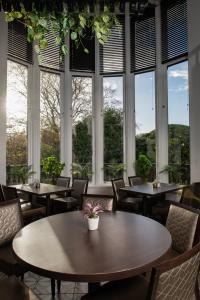 a room with tables and chairs and windows at Brig o' Doon House Hotel in Ayr