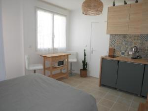 um quarto com uma cama, uma secretária e uma mesa em La maison aux bambous em Montreuil