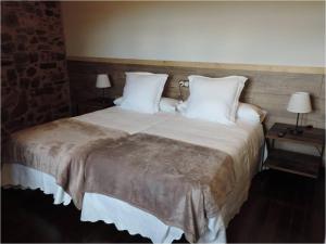 Un dormitorio con una cama grande con almohadas blancas. en El Rincón Maragato, en Castrillo de los Polvazares