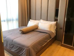 Ce lit se trouve dans une petite chambre dotée d'une grande fenêtre. dans l'établissement Condo Khaoyai at Forest Khaoyai, à Ban Thung Sawang