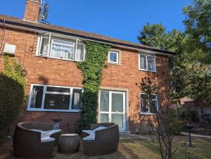 a brick house with two couches in front of it at Lovely 2 bedroom apartment with a garden in Royal Tunbridge Wells