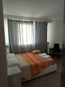 a bedroom with a bed with a curtain and a window at La torre in Latina