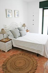sypialnia z dużym białym łóżkiem i dywanem w obiekcie Apartamento con vistas al mar 2 w mieście Port de la Selva