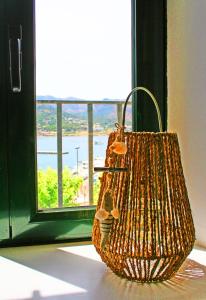 una cesta sentada en el suelo frente a una ventana en Apartamento con vistas al mar 2, en Port de la Selva
