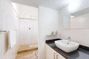 y baño blanco con lavabo y ducha. en San Lameer 2820 by Top Destinations Rentals, en Southbroom