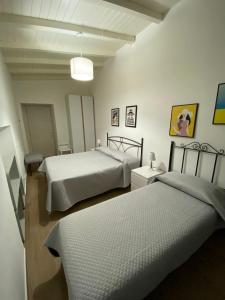 a bedroom with two beds and a mirror at Dimora Garibaldi Apartment & Room in Agrigento