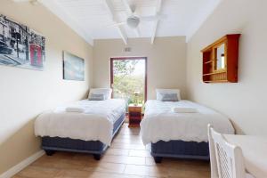 a bedroom with two beds and a window at San Lameer 2820 by Top Destinations Rentals in Southbroom +26 photos