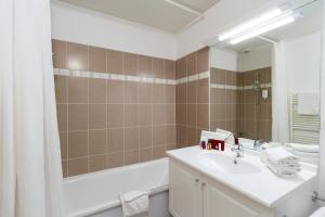 bagno con lavandino, vasca e specchio di Garden & City Clermont-Ferrand - Gerzat a Gerzat