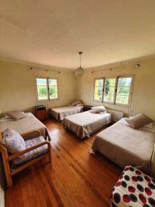 Un dormitorio con 3 camas y una silla. en Resort Amanda, en Quillón 64 fotos más