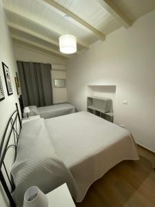 a white bedroom with a bed and a couch at Dimora Garibaldi Apartment & Room in Agrigento