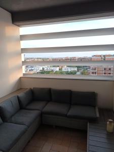 kanapa w pokoju z dużym oknem w obiekcie La torre w mieście Latina
