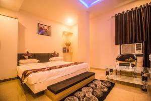 um quarto de hotel com duas camas e uma mesa em Capital O 5764 A Park Hotel em Gwalior