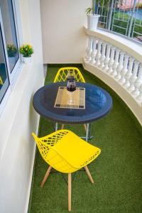 einen Tisch und einen gelben Stuhl auf dem Balkon in der Unterkunft Royal Haven A3 Spacious 1Br Apartment 10min drive to beach hosts upto 4 guests WiFi - Netflix, 10min drive to beach in Mombasa