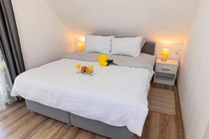 ein Schlafzimmer mit einem Bett mit zwei Gläsern und Blumen darauf in der Unterkunft Kuća za odmor Kostanjevec in Velika Gorica