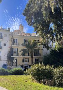 a large white building with a palm tree in front of it at La Ventana in Ibiza Town