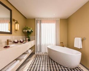 a bathroom with a large tub and a sink at Berbère Palace in Ouarzazate