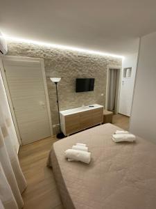a bedroom with a bed with two towels on it at Dimora Garibaldi Apartment & Room in Agrigento