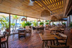un restaurante con mesas y sillas de madera y ventanas en Blue Bay Exclusive - 66, en Dorp Sint Michiel
