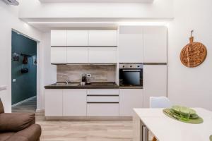 a kitchen with white cabinets and a counter top at [Linate Airport] Elegant Suite,Tram 1 minute away in Milan