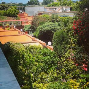 uma vista para um jardim com plantas e árvores em Enea residence em Pozzuoli