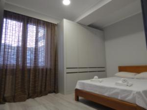 a bedroom with a bed and a large window at Confortable apartment in Chişinău
