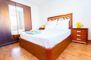 um quarto com uma cama grande e lençóis brancos em Apartamento Playa y Sol em Calpe