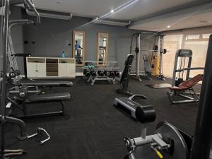 a gym with several treadmills and machines in it at Umhlanga Ridge One Bedroom Self-Catering apartment in Durban