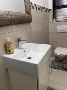 um lavatório branco numa casa de banho com WC em Umhlanga Ridge One Bedroom Self-Catering apartment em Durban