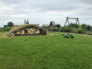 una casa con techo de hierba y una moto en un campo en Hof am Siel en Butjadingen