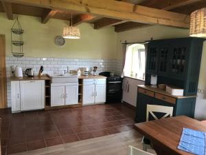 a large kitchen with white cabinets and a table at Hof am Siel in Butjadingen