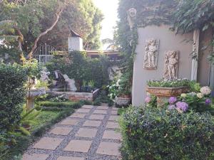 een tuin met een loopbrug met beelden en bloemen bij LAVENDER AND LACE GUEST FLAT in Pretoria