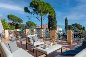 a patio with chairs and tables and a tree at Luxury Seaview Apartment in Opatija