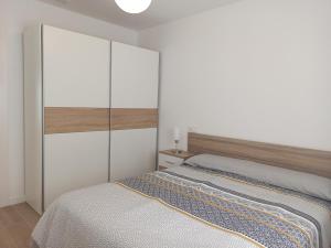 biała sypialnia z łóżkiem i szafką w obiekcie Casa cerca de la playa con patio y garaje privado w mieście Puerto de Sagunto +21 zdjęć