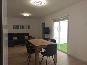 a dining room and living room with a table and chairs at Casa cerca de la playa con patio y garaje privado in Puerto de Sagunto