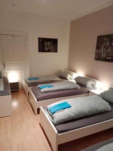 - 3 lits dans une chambre avec des oreillers bleus dans l'établissement Stadtnah an der Förde 75 1, à Flensbourg