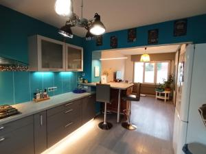 una cocina con paredes azules y una mesa. en Grande maison familiale 300 m de la plage et du centre, en Sangatte