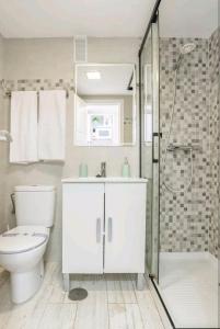 een witte badkamer met toilet en douche bij EL ESTUDIO DE LA PLAYA BENALBEACH Holidays Deluxe in Benalmádena